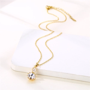 Elegant gold round zircon pendant necklace with dual sparkling crystals on white pedestal