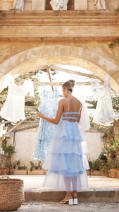 Outdoor lifestyle view of flowing light blue tiered organza summer evening dress