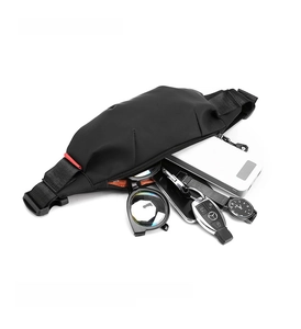 Mini black crossbody bag detail showing interior capacity with phone and accessories