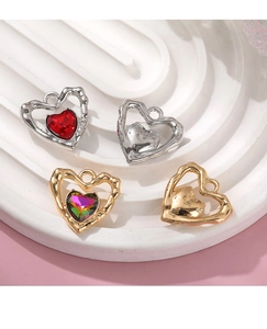Macro view of alloy heart charms with colorful crystals and hollowed textured frames