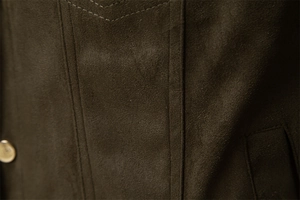 Macro detail of dark olive faux suede fabric with precise double stitching and metal button