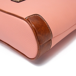 Detail of pink lychee leather texture with brown retro corners and white stitching