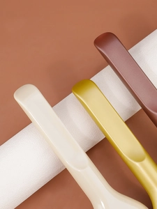 Close-up of thin flat resin foundation brushes with smooth matte finish in three colors