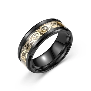 Macro detail of men's black stainless steel ring with gold dragon pattern inlay