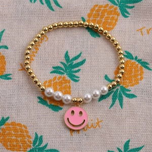 Gros plan détaillé du bracelet perlé avec smiley en émail rose et perles