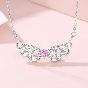 Detailed macro of S925 sterling silver wing necklace with pink heart-shaped gemstone