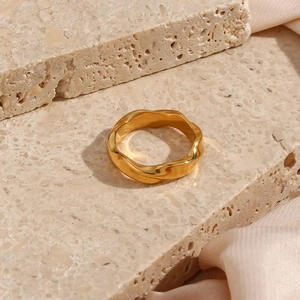 Detail view of 18k gold plated stainless steel ring with elegant geometric wave pattern