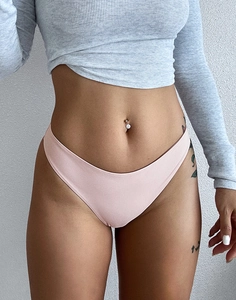 Detailaufnahme des hellrosa nahtlosen Eisseide-Tanga mit niedriger Taille am Modell