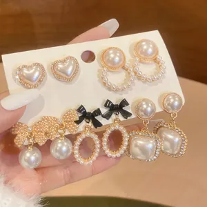 Elegant pearl earring set featuring bowknots and crystal studs in vintage gold finish