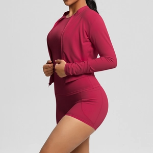 Vue latérale de l'ensemble de yoga rouge baie avec veste zippée ajustée et short taille haute