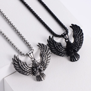 Retro stainless steel eagle pendant necklaces in black and silver on white geometric stands