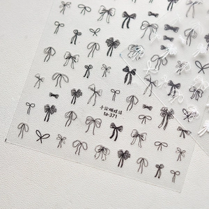 Macro shot of hand-drawn bow nail stickers in black and white, model ta-371 details