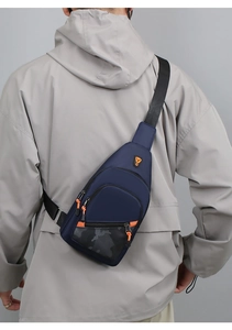 Men's navy blue chest bag with camouflage detail shown worn over a grey jacket
