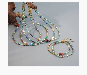 Detail view of colorful turquoise and red coral beaded necklaces draped on driftwood