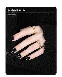 Close-up of gold S925 silver rings with bubble texture and crystal on black knit background