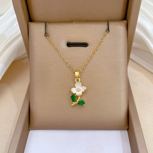 Detail of floral necklace with white petals and green teardrop gems in a jewelry box