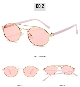 Detail view of oval double bridge sunglasses with gold metal frame and pink lenses
