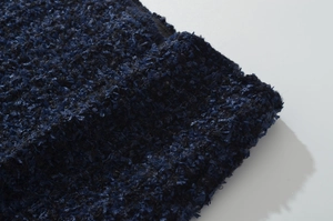 Dettaglio macro del tessuto in tweed testurizzato blu navy e nero con trama intrecciata