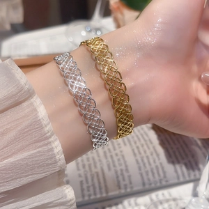 Détails macro des motifs circulaires évidés sur des bracelets en métal bicolore