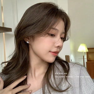 Elegant silver round cubic zirconia stud earrings worn by a model in warm light