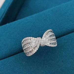 Macro detail of silver bow ring with micro-pave cubic zirconia in premium gift box