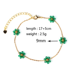 Golden woven bracelet featuring 9mm green flowers with 17+5cm length and 2.5g weight info