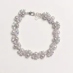 Elegant wave bracelet with white pearls and sparkling zircon crystals for women
