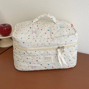 Quilted makeup bag with colorful polka dots and blue bow patterns on white background