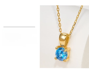 Macro view of gold-plated 925 silver necklace featuring a sparkling blue zircon pendant