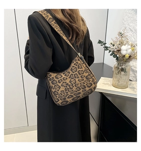Chic leopard print crossbody bag styled with a black blazer on a model for casual look