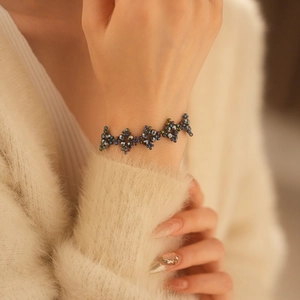Close-up of a handcrafted floral beaded bracelet featuring colorful pearls on a model wrist