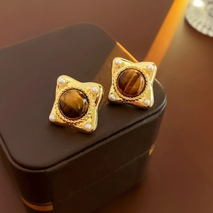 Detailed close-up of retro geometric resin earrings with tiger eye stone and pearls