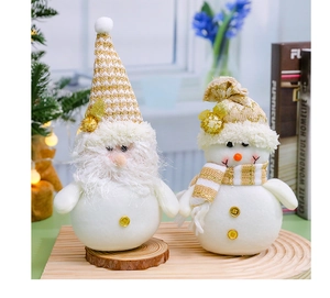 Detailed view of Christmas plush gnomes with gold knit hats on a rustic wood base