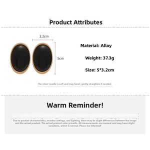 Vue détaillée de boucles d'oreilles ovales en résine noire avec bordure dorée