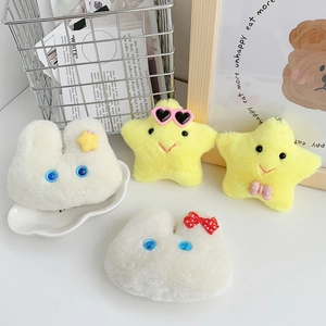 Detailed close-up of cute plush rabbit and yellow star pendants on a white table surface
