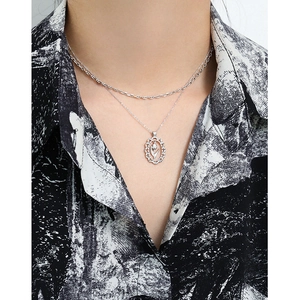 Silver double-layer necklace with oval hollow tulip pendant on elegant female model