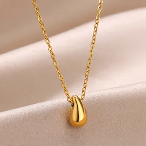 Macro view of a 18k gold-plated teardrop pendant on a matching stainless steel chain
