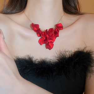 Detailed view of luxury red velvet petal tassel necklace on model with golden chain