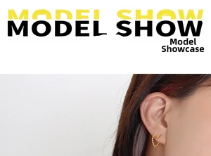 Close-up of golden irregular heart-shaped earrings with textured beaded finish on model
