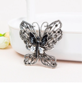 Detailed close-up of a butterfly brooch with black and white enamel and dark rhinestones