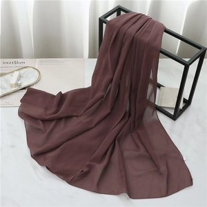 Close-up of a premium chocolate brown pearl chiffon scarf draped on a minimalist display