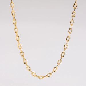 Detailed close-up of golden stainless steel twist chain necklace with textured oval links