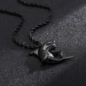 Detailed close-up of a black stainless steel shark pendant with a twisted rope chain
