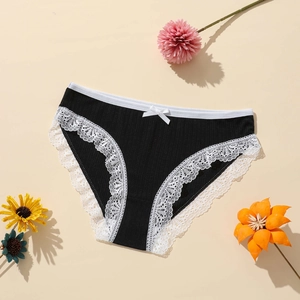 Detail of black knitted panties with white floral lace trim and a small bow decoration
