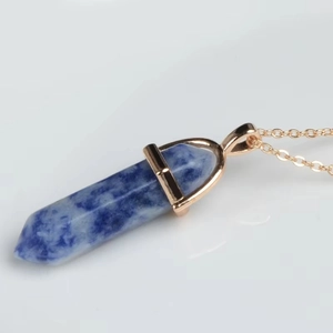 Macro detail of hexagonal sodalite pendant with rose gold finish chain and setting