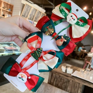 Detail shot of four Christmas hair clips with bows and festive charms on white card