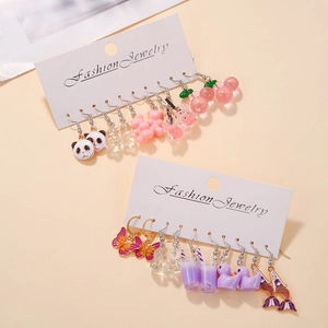 Détail de boucles d'oreilles en acrylique avec pandas, ours et papillons sur carton