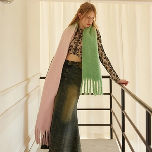 Chunky pink and green gradient wool blend scarf with tassels shown on a model
