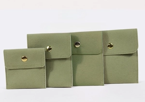 Détail d'un lot de 4 pochettes à bijoux en velours vert avec bouton-pression en métal