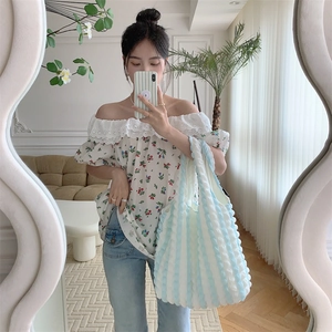 Blue and white striped bubble texture tote bag styled with floral crop top and denim